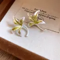 Close-up detail of delicate orchid flower earrings featuring green enamel and silver finish - Silver-Green