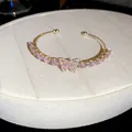 Elegant French style gold open bangle featuring pink zircon butterfly and teardrop stones - Gold-Pink