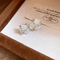 Detailed macro view of delicate forest-style flower earrings in a velvet jewelry box - Silver-White-Green
