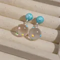 Close-up of clear resin earrings with colorful polka dots and marble beads - Silver Earring Post Style / Blue