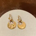 Elegant 18k gold plated hollow hulu earrings with zircon accents and hammered finish - Gold