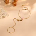 Vue détaillée du bracelet de doigt en acier titane doré avec pierre rose en goutte - Style Larme en Strass Rose