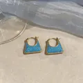 Detailansicht der 18k vergoldeten quadratischen Ohrringe mit blauen Zirkonia-Verzierungen - Gold-Blau