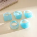 Detailed macro view of 5-piece light blue dyed resin rings with various geometric shapes - Five-Piece Set / Blue
