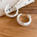 Elegantes pendientes de aro en C de encaje blanco con detalle de flores - Tops / Blanco