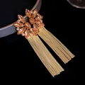 Close-up of elegant champagne crystal flower earrings featuring long gold chain tassels - Gold-Light Pink