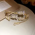 Close-up of elegant gold wheat leaf bracelet with sparkling marquise zircons - Gold