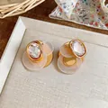 Detailed close-up of 18K gold plated geometric stud earrings featuring clear zircons - Geometric Flower Style (HE32294) / Gold