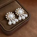 Elegant vintage pearl stud earrings with gold setting and teardrop pendants in a brown box - Gold