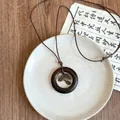 Detailed macro view of rustic wooden ring necklace with bronze leaf charms on ceramic plate - Necklace-Coffee-Gold