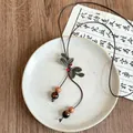 Close-up detail of retro ethnic style long necklace with leaf motifs and wooden beads - Necklace-Coffee-Gold-Leaf