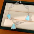 Close-up detail of a silver bracelet with hollow and light blue stone-set gourd charms - Silver-Blue
