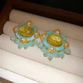 Close-up detail of vintage court-style oval earrings with blue resin and rhinestones. - Silver-Gold-Yellow