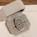 Detailansicht eines verzierten Gitterrings mit funkelnden Steinen in einer Box - Ovaler Hohler Strassstil (HR3481) / Silber