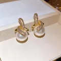 Detailansicht von hochwertig 18 Karat vergoldeten Zirkonia-Ohrsteckern mit weißen Perlen - Verdrehter Perlenstil (HE33236) / Gold-Weiß