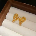 Vista macro dettagliata di orecchini a lobo a forma di cuore placcati oro con zirconi - Oro