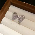 Dettaglio macro di orecchini a lobo a cuore placcati oro 18k con zirconi scintillanti - Argento