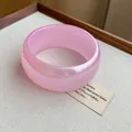 Detalle macro del brazalete ancho rosa transparente iridiscente en fondo estético - Rosa Claro