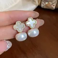 Macro detail view of elegant four-leaf clover pearl earrings with sparkling zircon inlay - Clover Pearl Drop Style