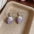 A detailed view of sweet purple oil-dripped strawberry pendant earrings on a beige tray. - Silver Earring Post - Silver - Purple