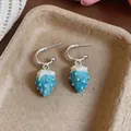 Detailed close-up showing blue and white enamel strawberry drop earrings in a tray - Silver Earring Post - Silver - Blue