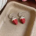 Detailed view of red strawberry drop earrings with silver hoops on a beige tray. - Silver Pin - Silver - Red