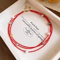 Detailed view of a multi-layer red beaded necklace featuring various colorful pearls - Red