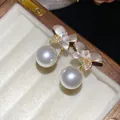 Close-up of elegant flower and pearl earrings with cubic zirconia accents - Silver Earring Post-White