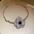 Gros plan d'un ras-du-cou floral en strass avec un design de branche argentée bijoux - Argent