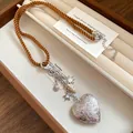 Close-up of vintage engraved silver heart pendant with shell and star charms - Silver Heart With Coffee Rope