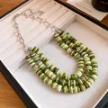 Close-up detail of multi-layer shell beaded necklace with vibrant green gradient tones - Necklace / Green
