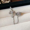 Detail view of a silver cross earring and butterfly ear cuff connected by a metal chain. - Ear Bone Clip (Single) / Silver