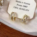 Detail of 14k gold-plated C-shape earrings with shell inlay and zircons on display card - Double Layer C-Shape Shell Zirconia Studs / Gold (Real Gold Plated)