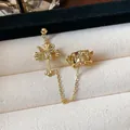 Detailed close-up of a 18k gold plated cross and butterfly ear cuff with chain connection. - Ear Bone Clip (Single) / Gold