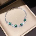 Detailed macro shot of an elegant silver bracelet with sparkling green and clear stones. - Style 7 Bracelet / Silver/Green