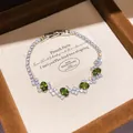 Close-up of sparkling silver-toned tennis bracelet with five oval green gemstones. - Style 9 Bracelet / Silver Olive Green