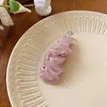Primo piano di un elegante fermaglio per capelli in chiffon rosa su piatto crema. - Rosa