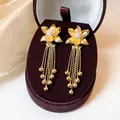 Detailansicht der 18k vergoldeten Blumen-Tassel-Ohrringe mit Zirkonia in einer Box. - Blumenquasten-Stil (Silberstift) / Gold