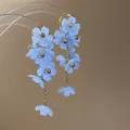 Gros plan de boucles d'oreilles à fleurs bleues avec détails de chaînes dorées élégantes - Bleu (Tige en Acier)