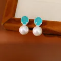 Detailed view of elegant turquoise oval zircon and white pearl drop earrings. - Lake Blue Oval Zirconia White Pearl Style / Silver