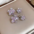 Detail view of shimmering pink zircon flower-shaped silver stud earrings on a display - Double-Layer Flower Design / Pink