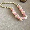 Collier élégant perles marbrées roses avec breloques fleurs crème et accents métalliques dorés - Or-Rose