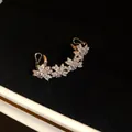 Macro detail of 14k gold-plated zircon flower ear cuff resting in a black velvet jewelry box - Single Piece / Silver