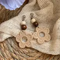 Gros plan sur des boucles d'oreilles bohèmes en rotin tressé main avec perles en bois. - Fleur en Rotin Tissé / Café (Tige de boucle d'oreille en argent)