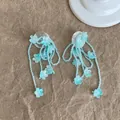 Nahaufnahme von blauen Perlenblumen-Quastenohrringen mit feinen Blütendetails - Blau