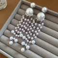 Macro detail showing multiple strands of pearls on vintage style tassel earrings - Silver