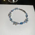 Elegant silver-tone bracelet featuring sparkling blue cubic zirconia and floral accents - 64# Bracelet / Silver Blue