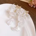 Close-up of elegant white chiffon flower tassel earrings with sparkling zircon studs - White
