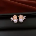 Detailed view of elegant flower stud earrings featuring white pearls and marquise stones - White Flower Style / Gold