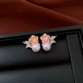 Detail shot of elegant pink enamel flower earrings with pearl and marquise zircon accents. - Pink Petal Style / Gold